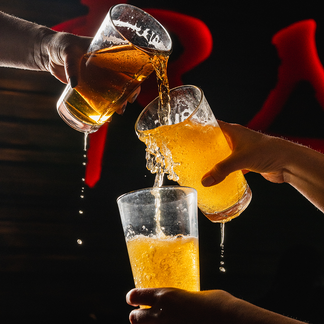 Beer being poured, trickling into below glasses